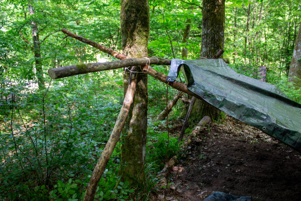 Abri en bois et bâche monté en sous-bois lors d’un stage Red Zone Project